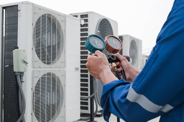 Engineer checking refrigerant pressures on condenser units