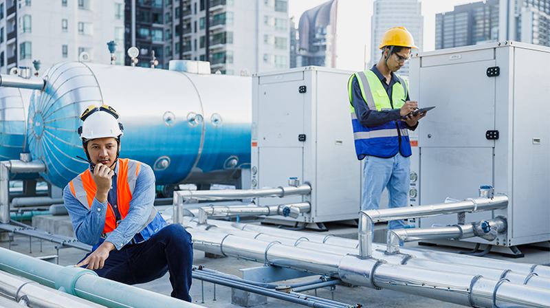 Technicians inspecting rooftop mechanical plant