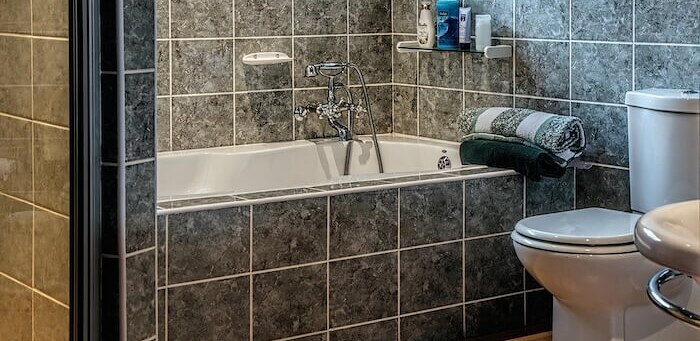 Tiled bathroom with bath, mixer taps and sanitary fittings installed