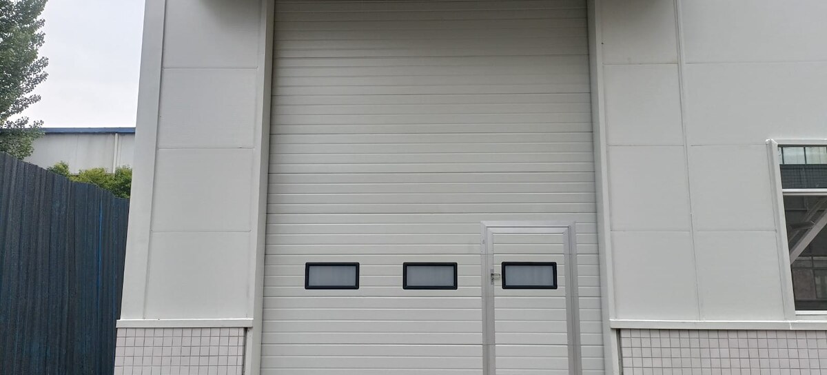 Industrial sectional door with a pedestrian access door in a warehouse facade